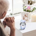 Small urns for human ashes with blue butterflies, tiny keepsake urn on windowsill, elderly lady in peaceful memorial moment
