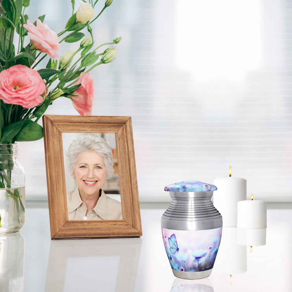 Cremation urns with blue butterfly design, small remembrance ash urn displayed with wooden photo frame and candles