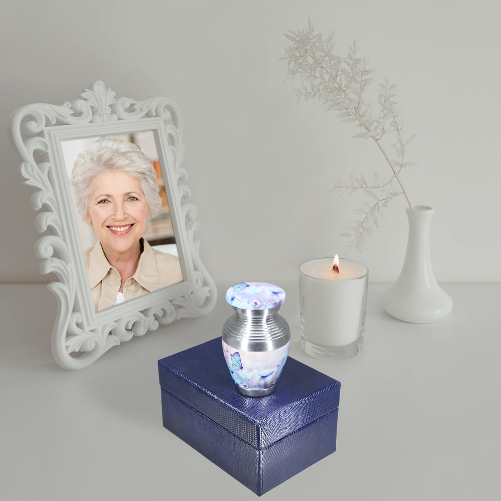 Tiny urns for ashes with blue butterfly print, small tribute urn on blue gift box with ornate photo frame decor