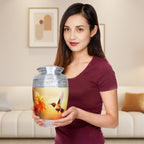 Lady holds buttery yellow hummingbird aluminum cremation urns for adults, silver etched design honoring loving mother