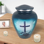 Christian urn for ashes with turquoise cross artwork displayed with candles for peaceful home remembrance