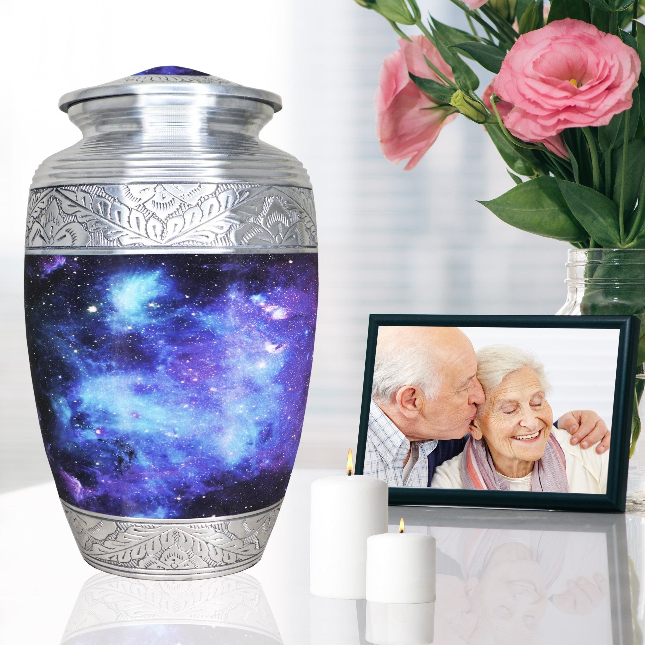 Blue galaxy funeral urn displayed beside a family memorial portrait and pink flowers for peaceful remembrance
