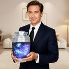Man holding a full-size urn for cremated remains with blue galaxy artwork, showing the adult memorial urn for scale