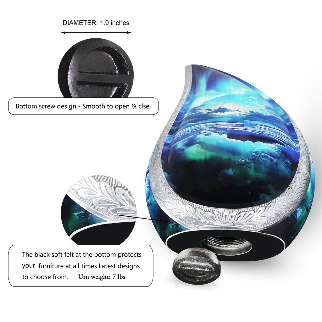 Aurora teardrop ash vessel set on glossy table next to couple photo, pink blooms and memorial remembrance candles