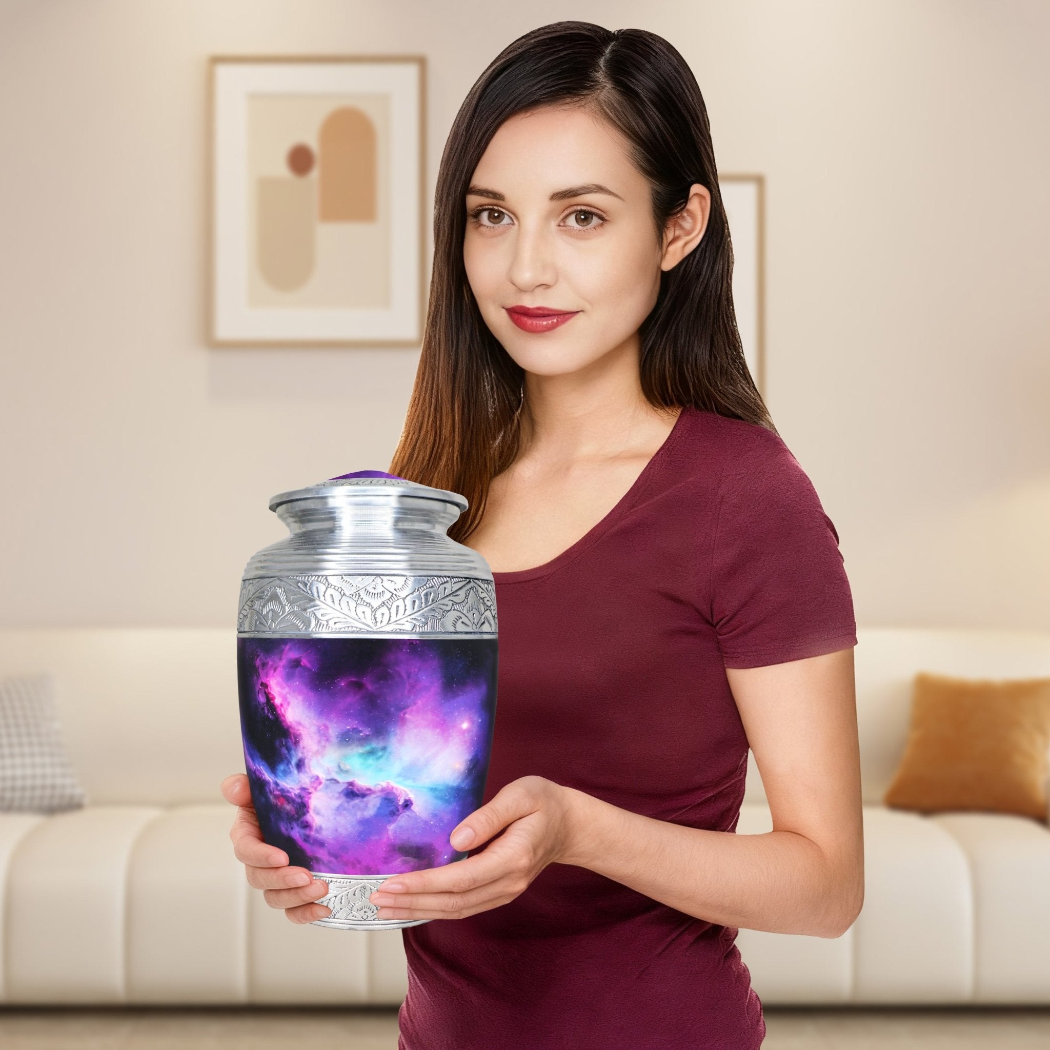 Woman holding polished metal cremation urns for adults, violet nebula decorative urn for home memorial display