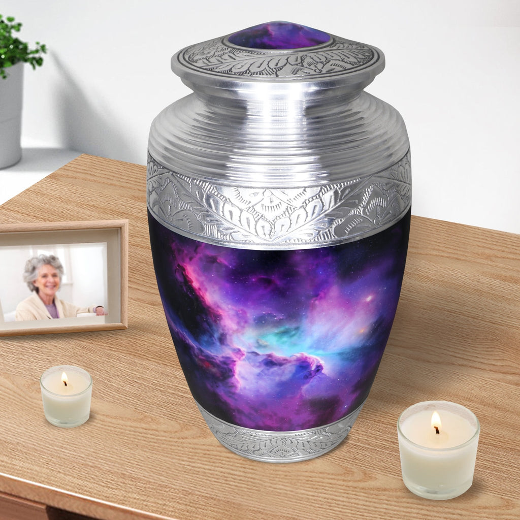 Adult urn for cremated remains with violet nebula artwork displayed on a tabletop with candles and framed photo