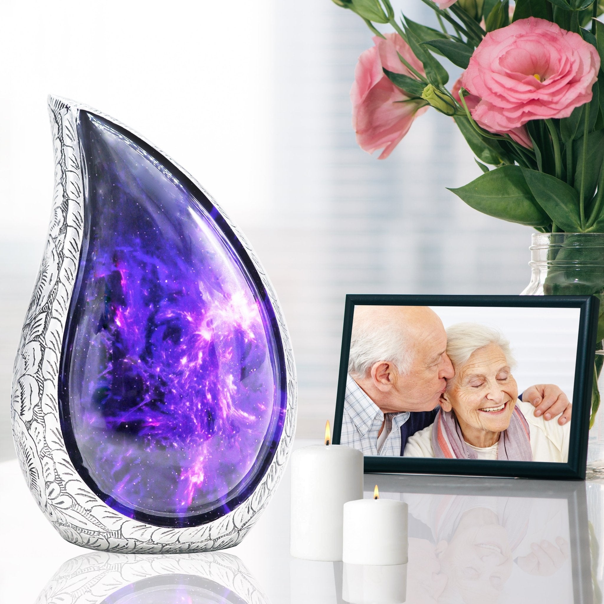 Purple galaxy funeral urn displayed beside pink roses and a framed memorial portrait for remembrance