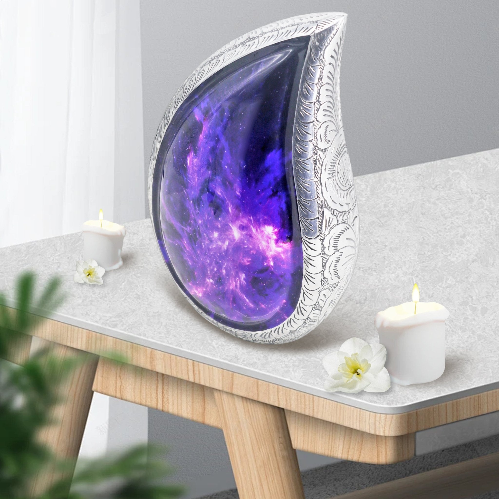 Modern amethyst-inspired urn with cosmic galaxy artwork displayed on a home memorial shelf with greenery
