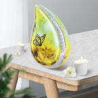 Sunflower butterfly metal burial urns teardrop shaped placed on wooden side table with candles for home mantel decor