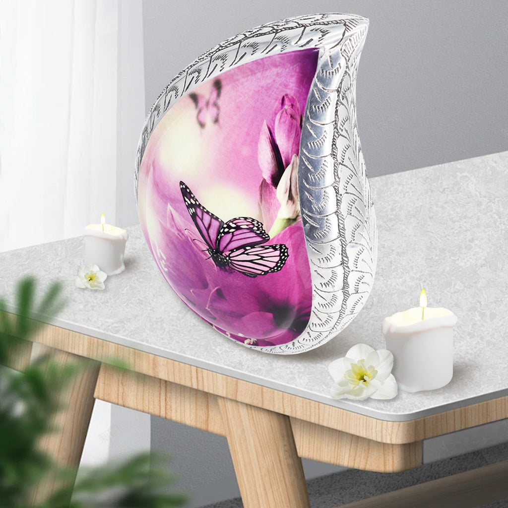 Pastel purple butterflies aluminum adult urn set on light wood side table with candles for warm indoor remembrance