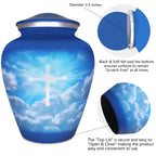 Metal cremation urn with luminous cross and cloud artwork, secure threaded top lid shown in detailed close-up