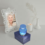 Miniature urns for ashes beside a memorial portrait, a heartfelt baby urn honoring a precious child