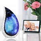 Cosmic star night urn by framed family photo with pink roses, heartfelt remembrance vessel for cherished loved one remains