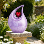 Purple cremation urn resting on garden stone, peaceful outdoor memorial urn for backyard or garden remembrance