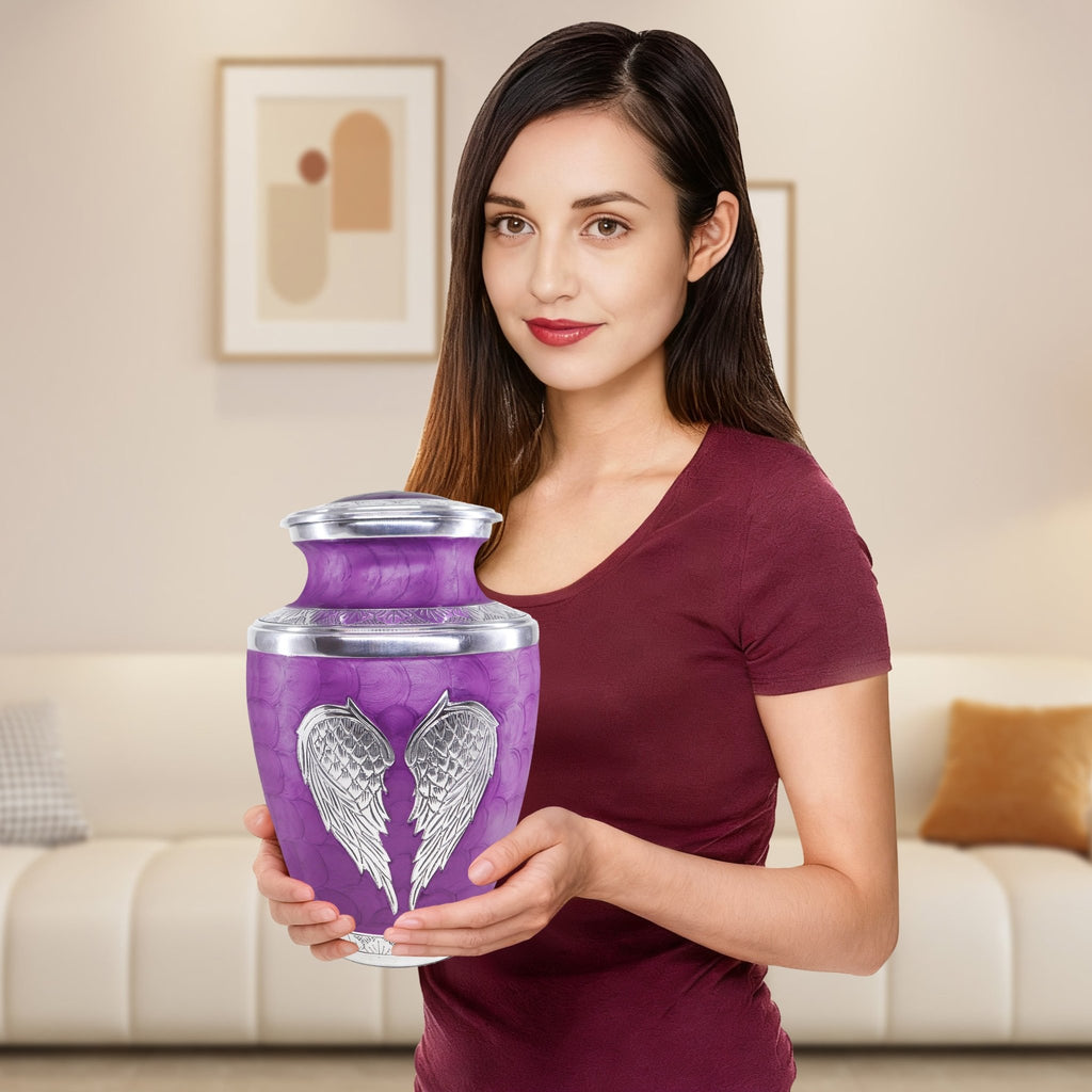 Big purple intricately engraved angel urns for mom held by woman, full size aluminum urn for size reference