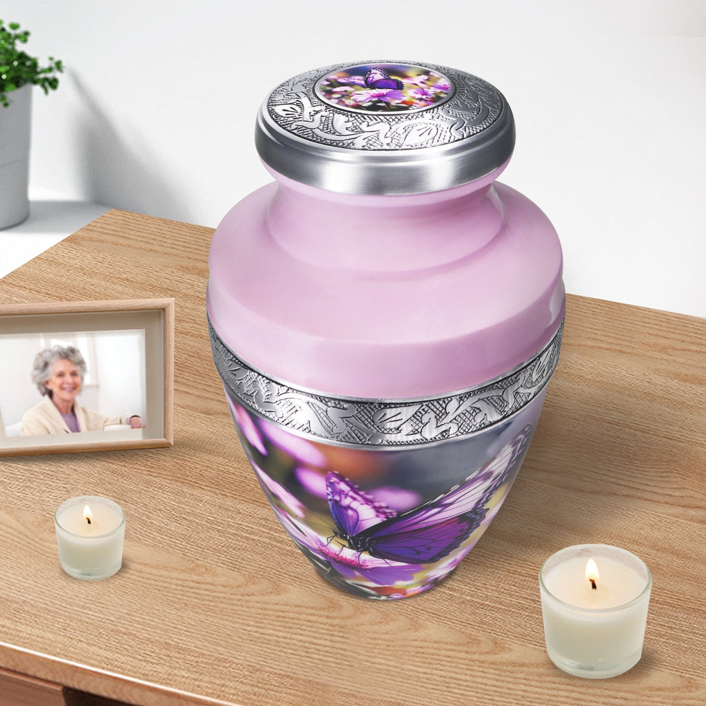 Purple urns for human ashes beside candles, engraved aluminum vessel preserving memories of a loved one