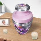 Purple urns for human ashes beside candles, engraved aluminum vessel preserving memories of a loved one
