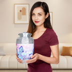 Woman holding aluminum cremation urns for adults, engraved blue butterfly flower large memorial urn for home display