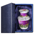 Keepsake urn for ashes with purple butterfly floral artwork, presented in a padded blue gift box for family remembrance