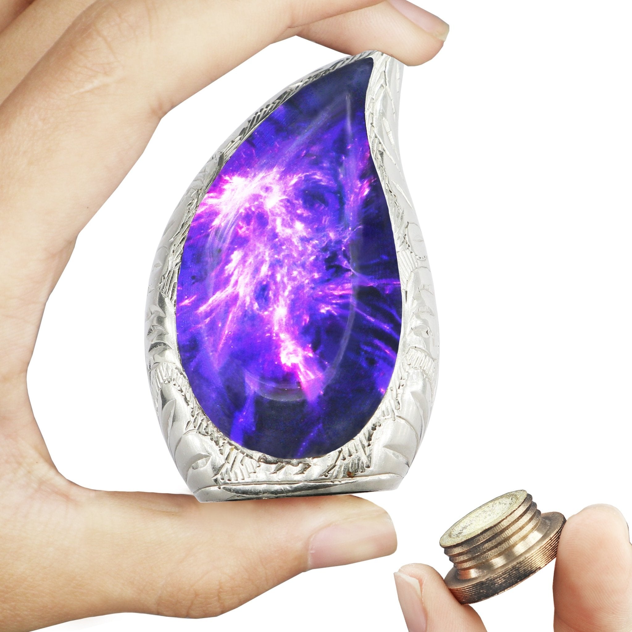 Hands holding purple cosmic nebula brass teardrop mini urn with detached threaded bottom lid for storing human memorial ashes