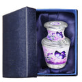 Keepsake urns for ashes with purple butterfly artwork presented in a padded blue gift box