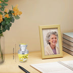 Tiny urns for ashes with yellow butterflies beside a family photo, a heartfelt memorial for a cherished mom