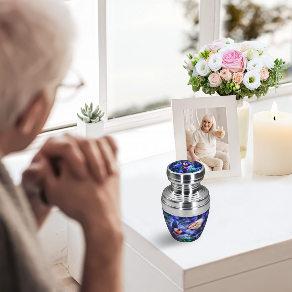Cremation urns for human ashes with blue butterfly artwork, woman honoring her beloved husband at home
