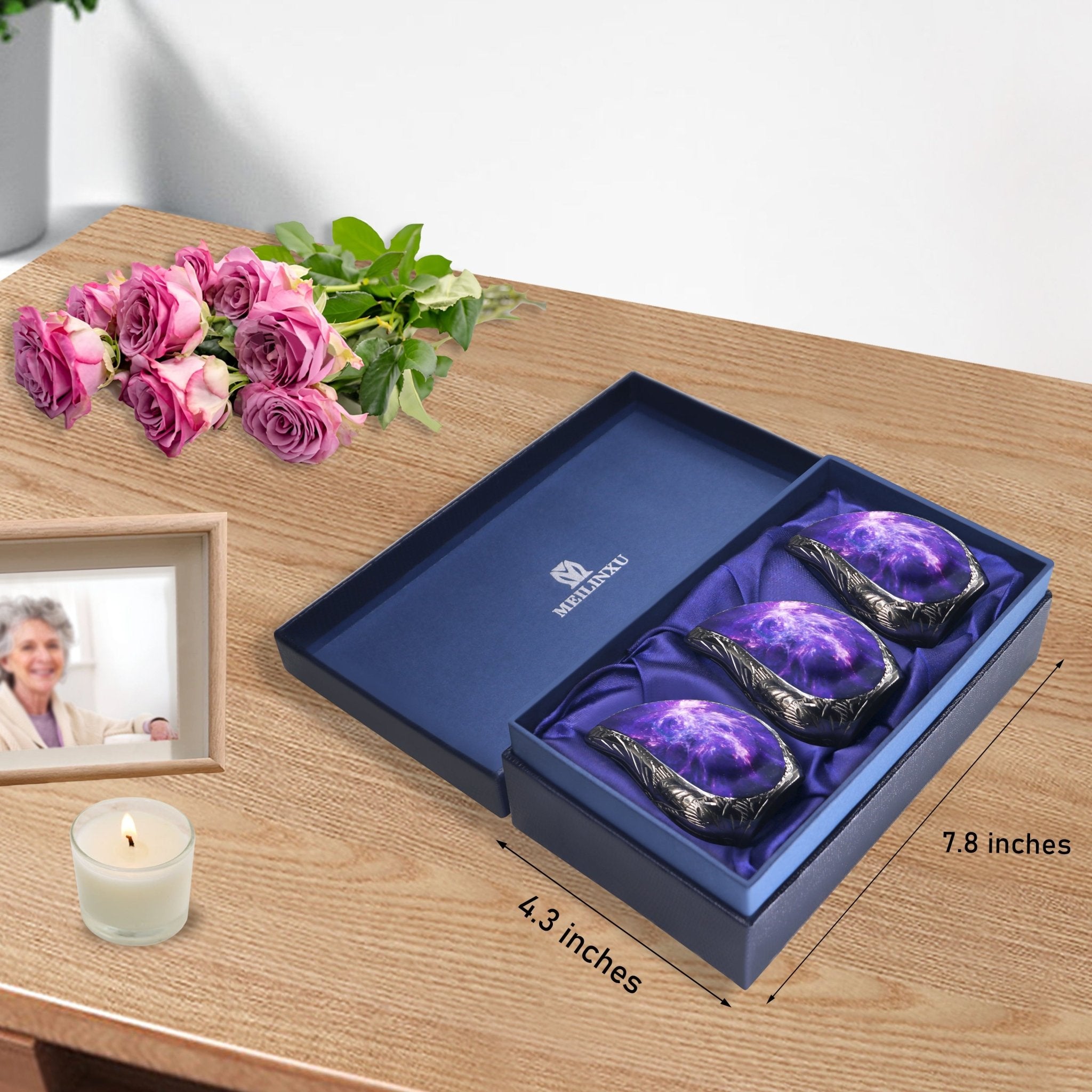 Keepsake urn set with three purple cosmic galaxy brass urns arranged inside a blue presentation box