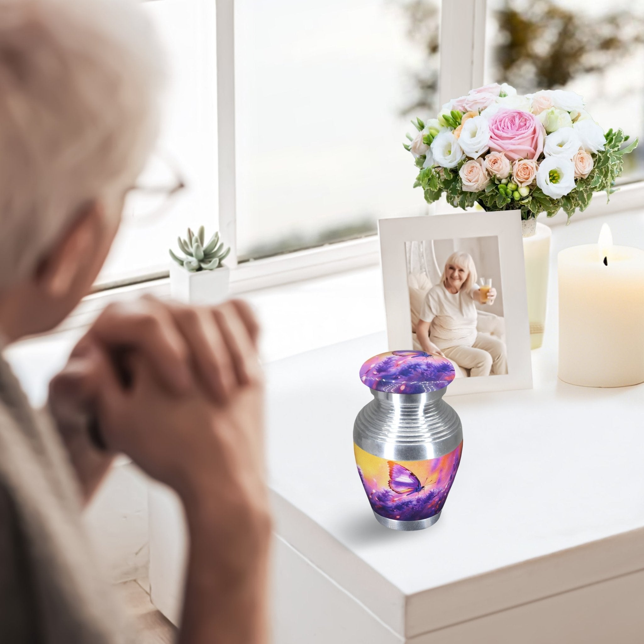 Small urns for human ashes with lavender butterfly design, tiny keepsake urn on windowsill, senior lady mourning by memorial