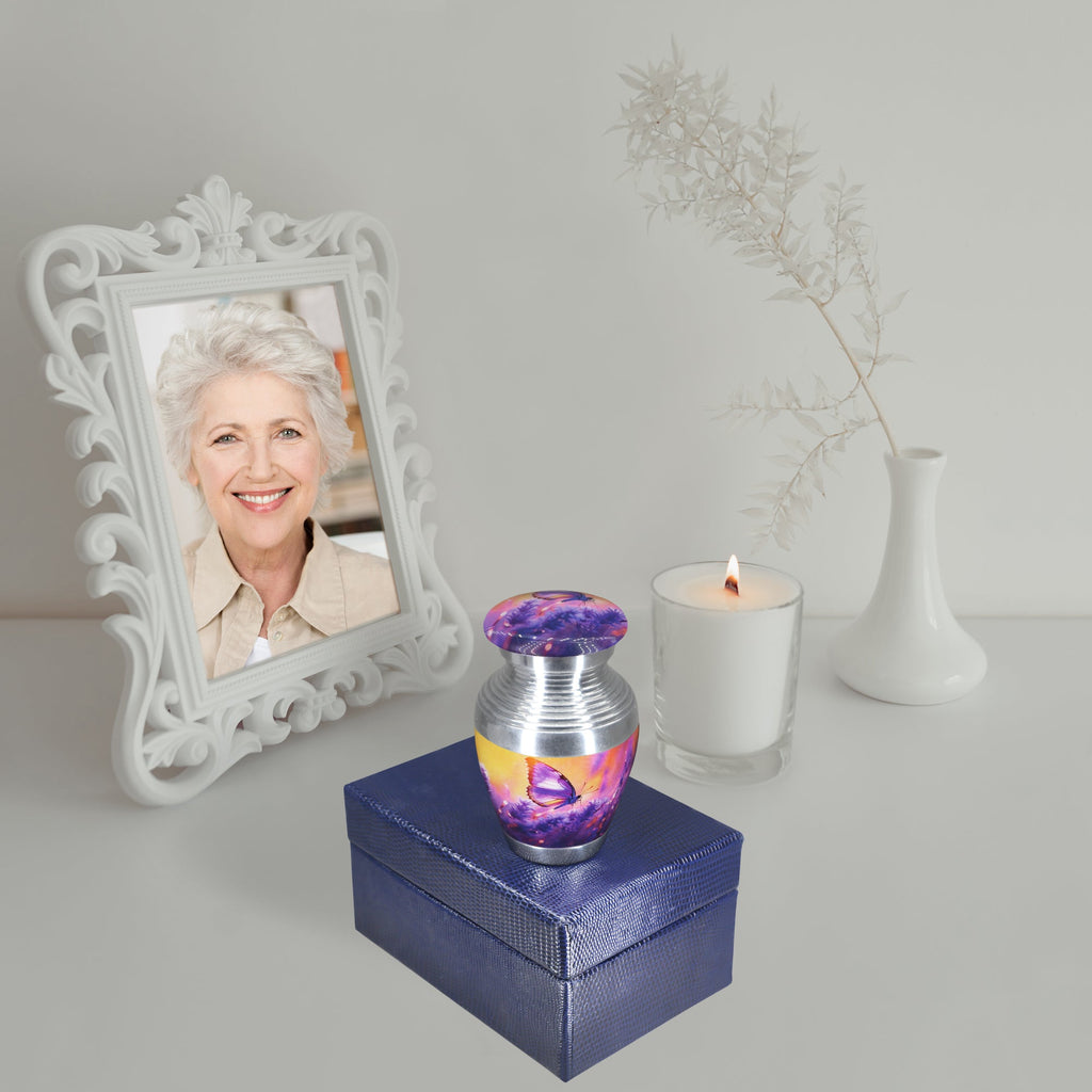 Small urns for ashes with lavender butterfly art, miniature memorial urn on blue gift box, decorated with candle