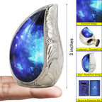 3-inch compact blue galaxy brass micro memorial urn held in palm to showcase tiny miniature storage capacity