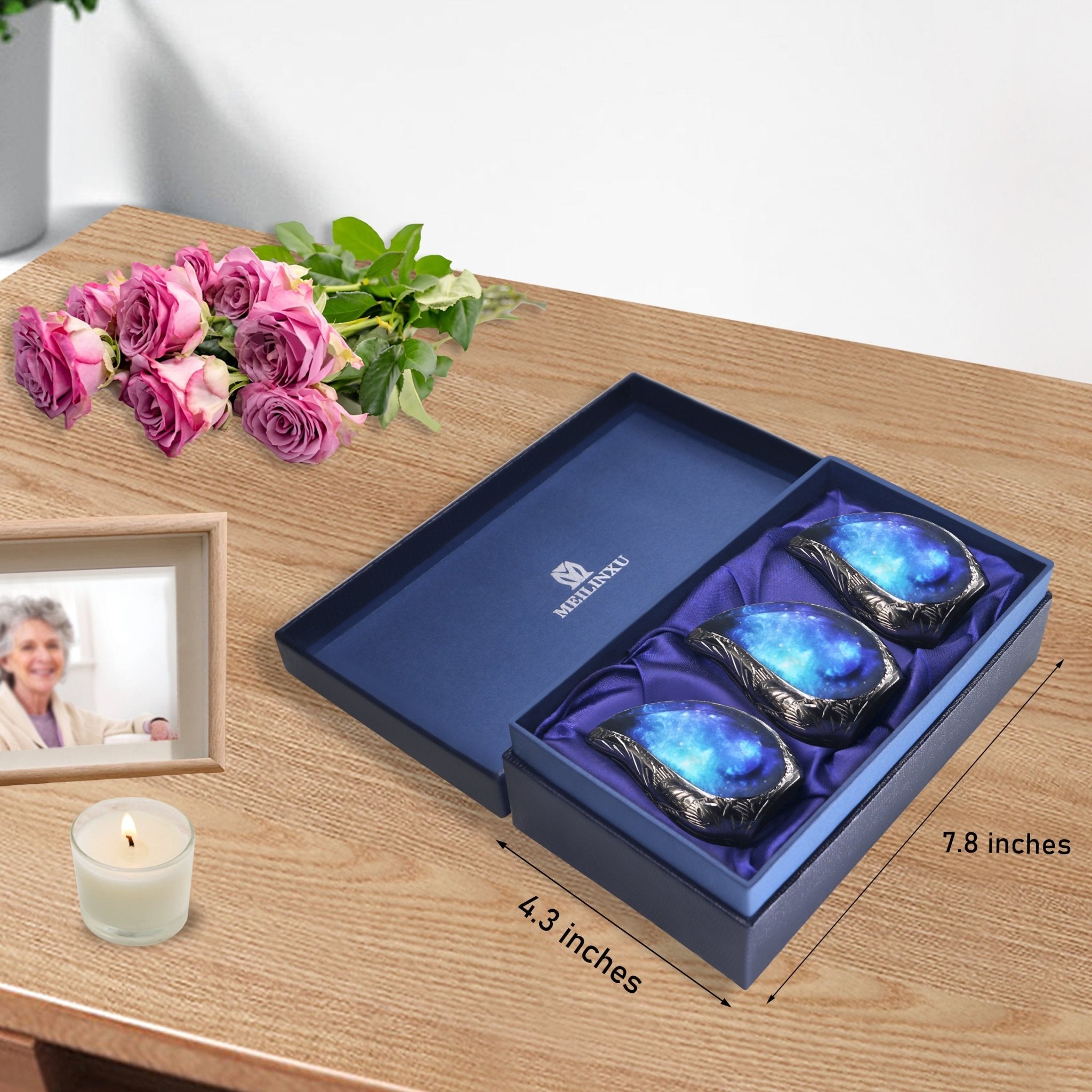 Complete bundle of blue starry brass teardrop ash urns paired with orange blooms inside luxury presentation gift box