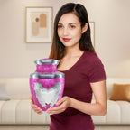 Full size pink delicate engraved angel & heart cremation urns for adults for beloved partner, shown in hand