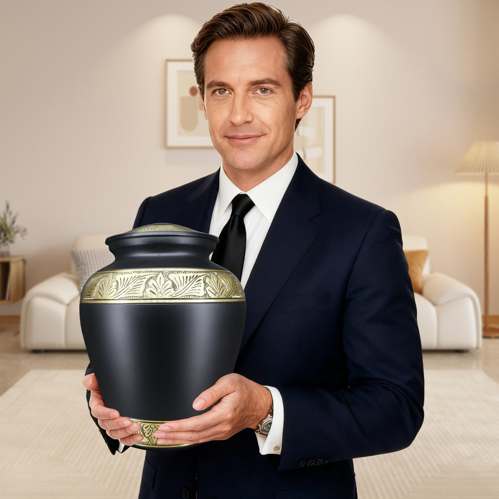 Man holds sleek black gold engraved metal urns for ashes for adults male, dignified memorial tribute for dear father