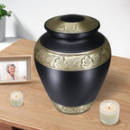 Classic black ornate gold trim aluminum vessel holding ashes in an urn, peaceful table memorial for cherished mom